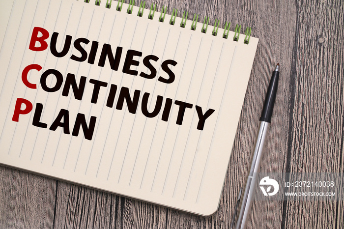Business continuity plan, text words typography written on book against wooden background, life and 