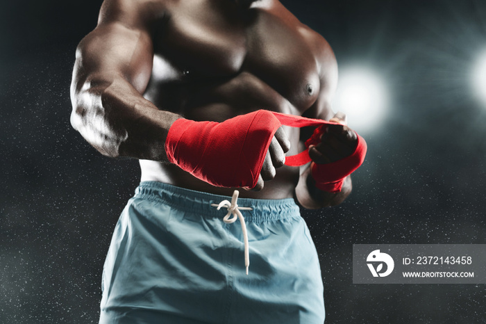 Fighter preparing for training, wrapping hands with boxing wraps