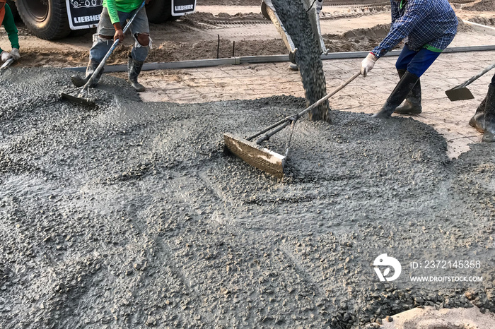 Workers pouring reinforced concrete floors on site