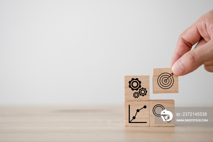 Hand putting print screen dart and target board wooden cube with magnifier glass graph and cog. Targ