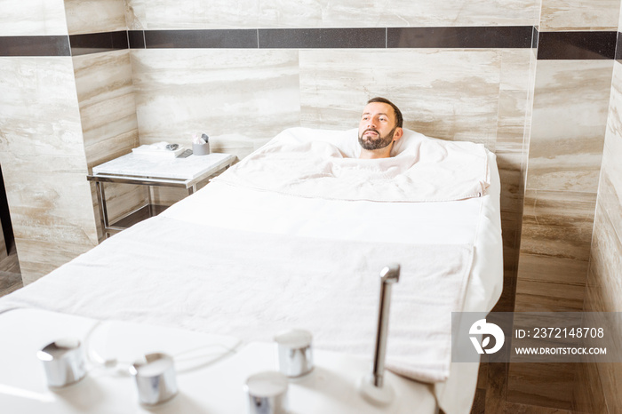 Man relaxing during a medical treatment at the bath filled with carbon dioxide at balneology room