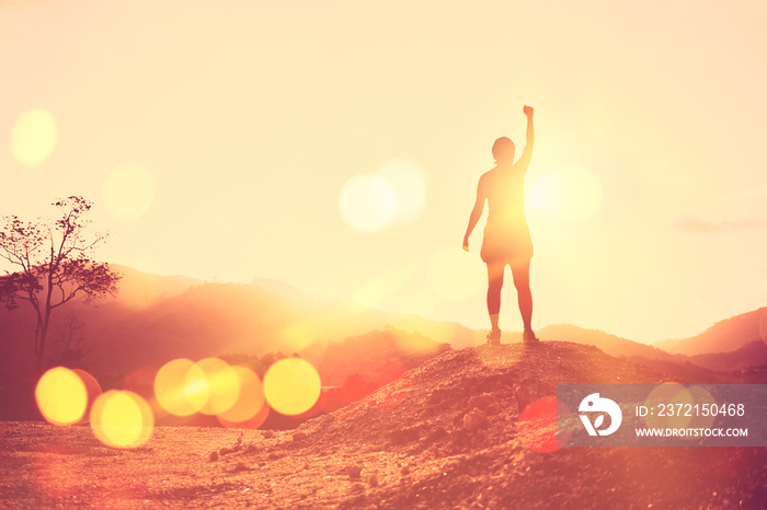 Copy space of woman rise hand up on top of mountain and sunset sky abstract background.