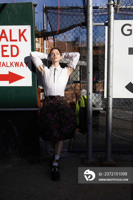 fashion portrait of non-binary person with short hair in chaotic city scene