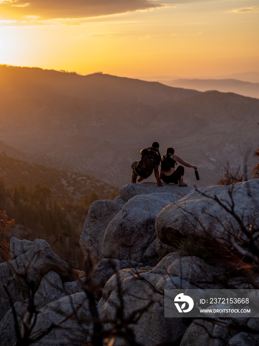 Vertical image of young native friends about to sit and watch the sunset