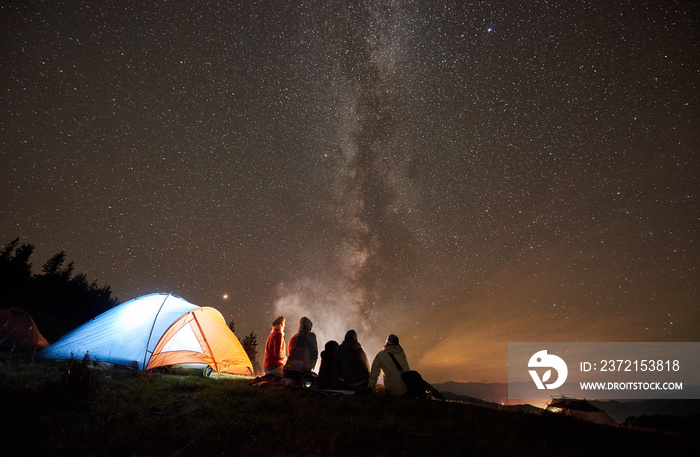 在山上进行夏季夜间露营。后视，五个年轻朋友组成的徒步旅行者正在休息。