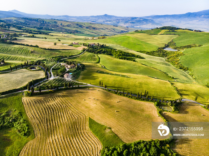 Stunning aerial view of green fields and farmlands with small villages on the horizon. Rural landsca