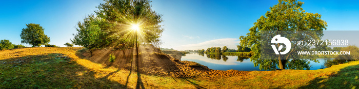 Landschaft im Herbst - Panorama mit Fluss und Bäumen bei Sonnenaufgang