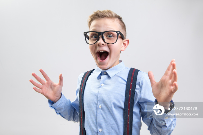 Wow. Waist up portrait of shocked child opening his mouth with pleasant surprise. He is looking at c