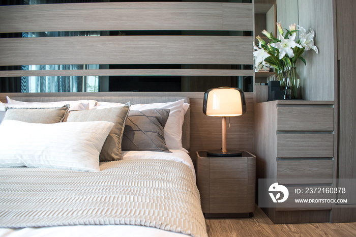 Modern bedroom interior design with brown and gray striped pillows.