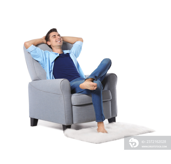 Young man relaxing in cozy armchair on white background