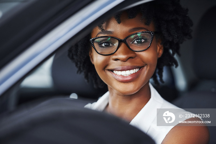 开心一笑。年轻的非裔美国妇女坐在一辆现代新车里
