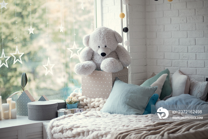 cozy childrens room in bright soft colors, pillows and a blanket are lying on the bed