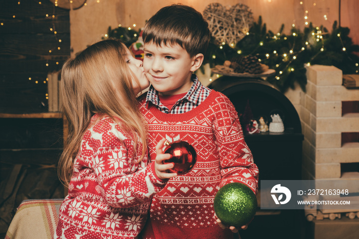 Lovely kiss. Cute little girl and boy play ornaments balls christmas tree. Kid enjoy winter holiday 