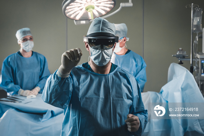 Group of surgeons using augmented reality holographic hololens glasses while operating in modern ope