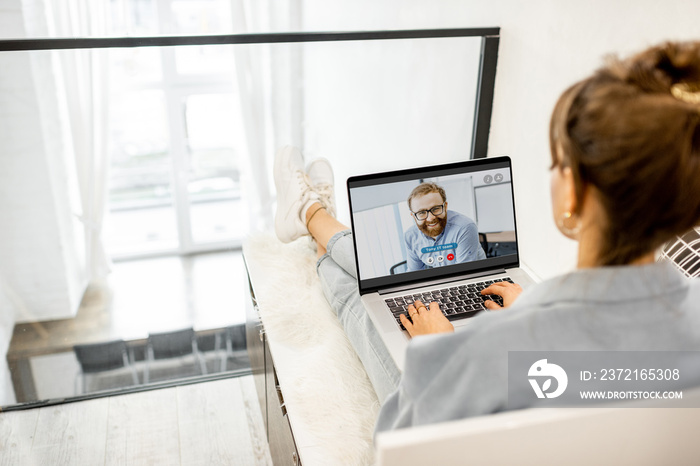 Business woman having a video call with coworker, working online from home at cozy atmosphere