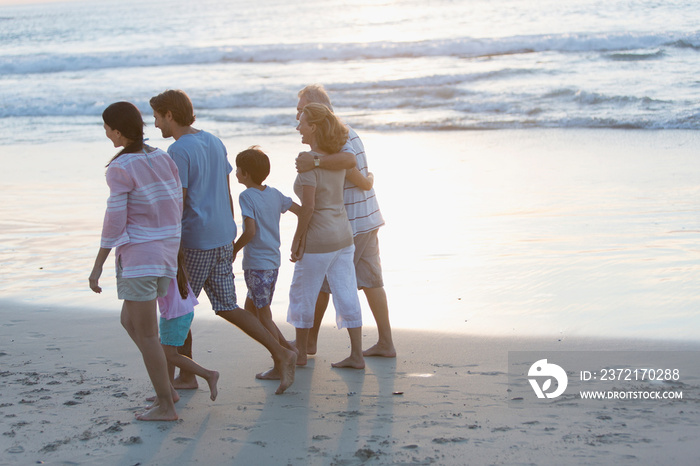 Multi-generation family walking on sunset beach