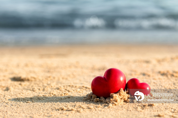 Small red hearts on beach sand