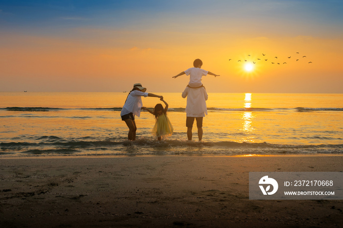 Cheerful family are dancing on the beach and sunset in the summer.