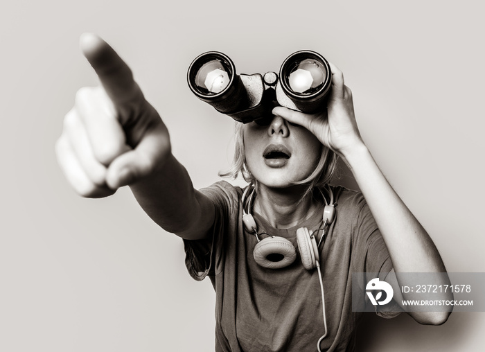 Young style girl with binoculars. Clothes in 1980s style. Image in black and white color style