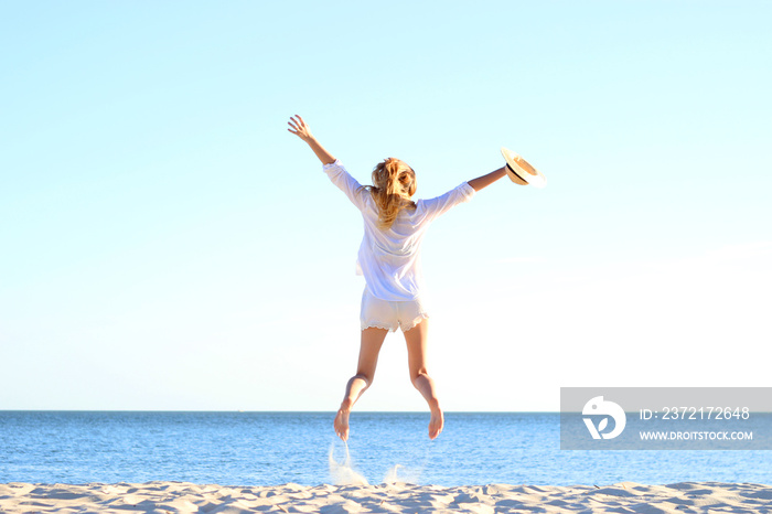 the girl is jumping against the sea.