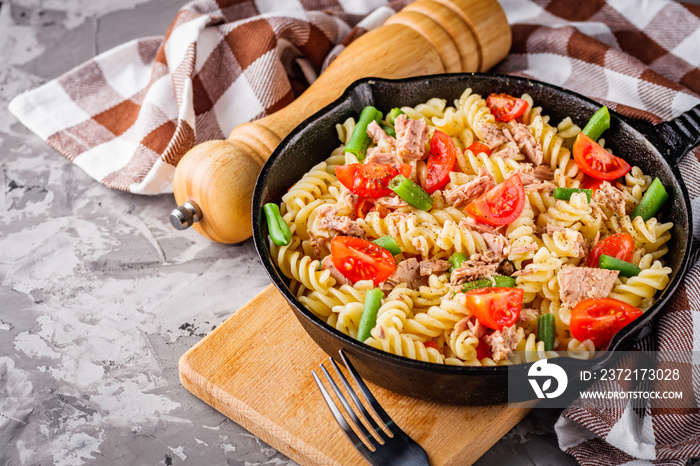 delicious traditional Italian pasta with tuna on a dark rustic stone background