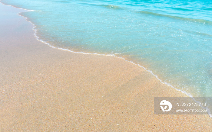 Brown sand beach and small wave of blue water in the sea