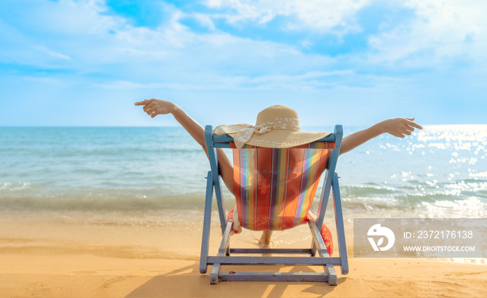 Summer beach vacation concept, Asia woman with hat relaxing and arm up on chair beach at Koh Mak, Tr