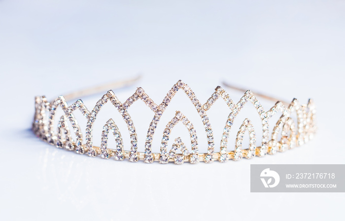 Closeup of crown decorated with shiny gems on white background