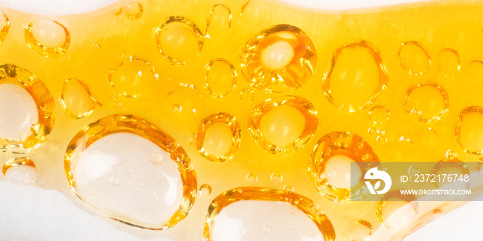 piace golden dab concentrate of cannabis wax close up on yellow background, marijuana resin