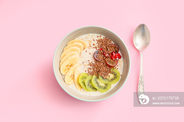 Tasty yoghurt with fruits and flax seeds in bowl on color background