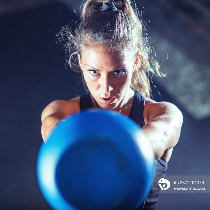 Woman athlete exercising with kettlebell