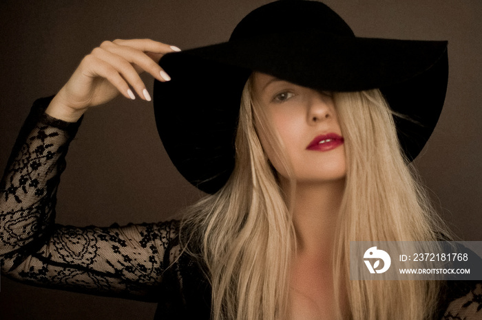 Classy blonde woman wearing a hat, artistic film portrait for fashion campaign and beauty brand desi