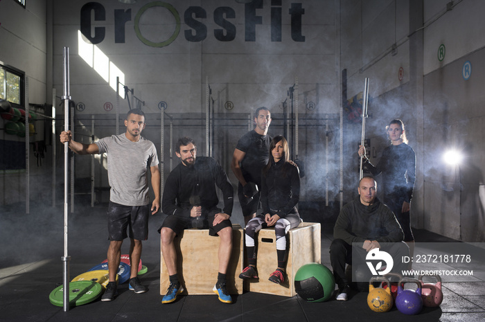 Crossfit team. Athletes posing with sport equipment