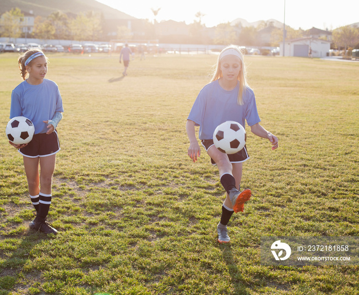 Girls practicing soccer on grassy field