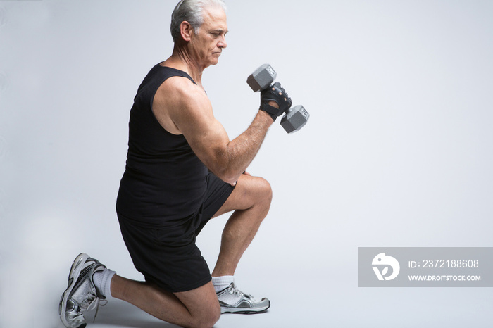 Senior man in sports clothing lifting broccoli