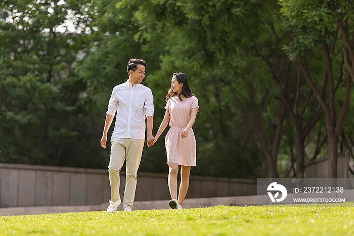 快乐的年轻夫妇在公园散步