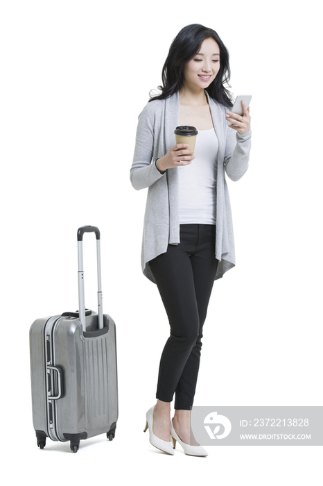 年轻女子带着旅行箱和手机旅行