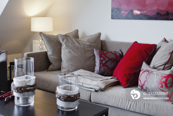 Candlestick holders on coffee table against sofa in contemporary house