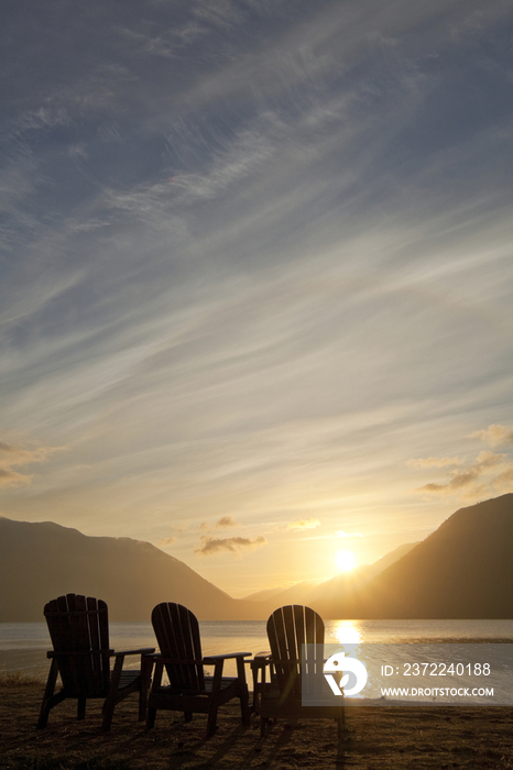 Three traditional Adirondack style wooden lounge chairs