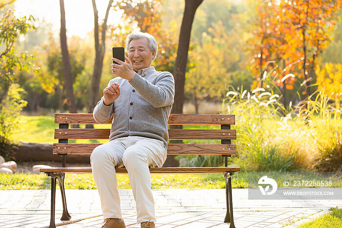 老年男子在公园使用手机