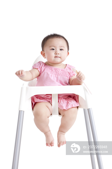 可爱女婴和婴儿餐椅