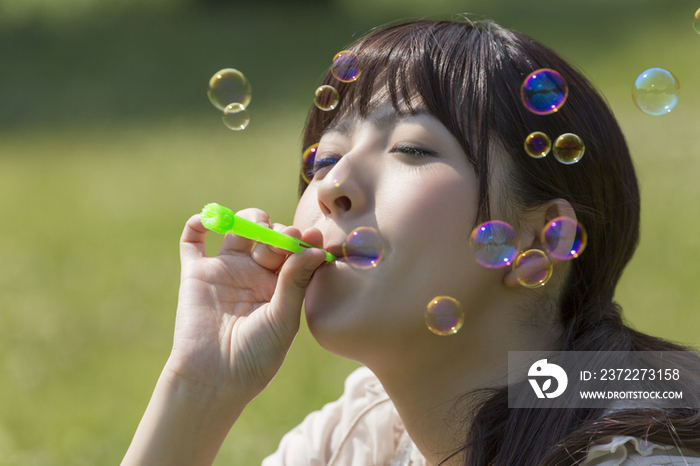 Young woman playing with bubble wand