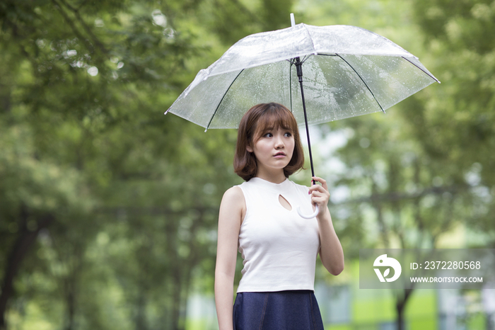 闷闷不乐的年轻女子打着雨伞