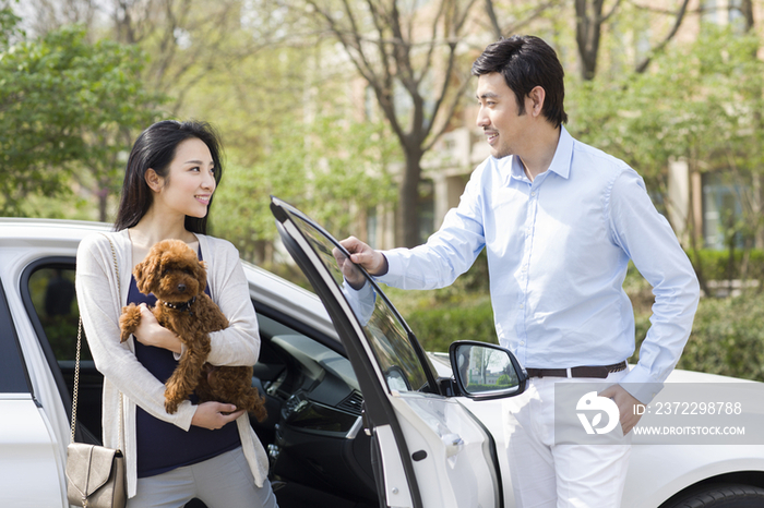 年轻夫妇带着宠物狗下车