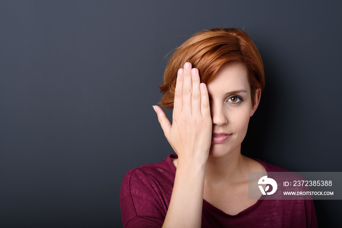 frau hält sich eine hand vor das auge