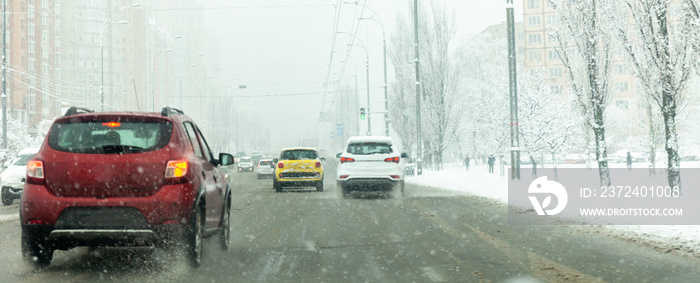 汽车在泥泞、暴风雪中行驶。城市交通在暴风雪中。