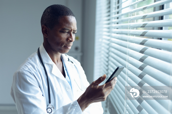 Male doctor using mobile phone in hospital