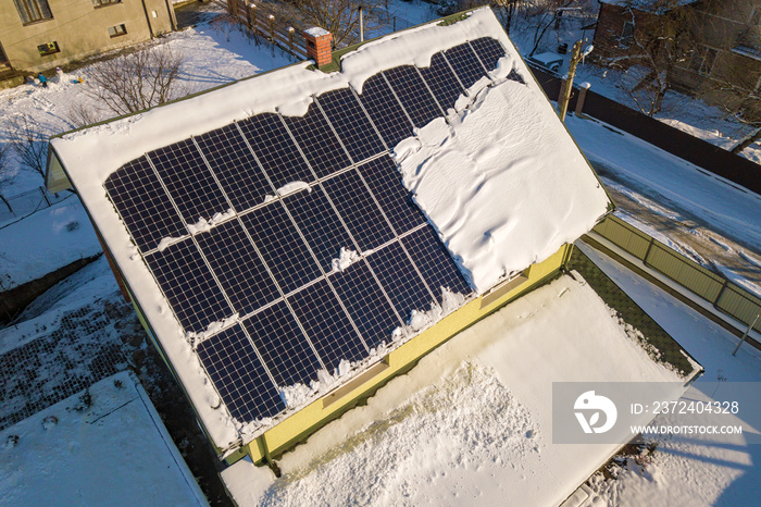 冬天屋顶覆盖着太阳能电池板，上面有雪。能源效率和维护c