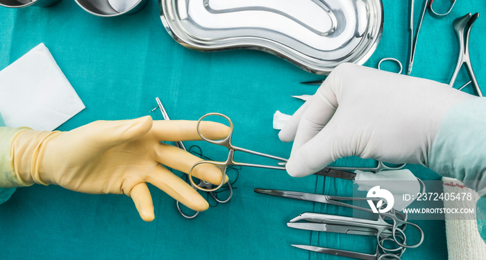 外科医生在手术室工作，戴着手套的手拿着缝线和托伦达的剪刀，概念