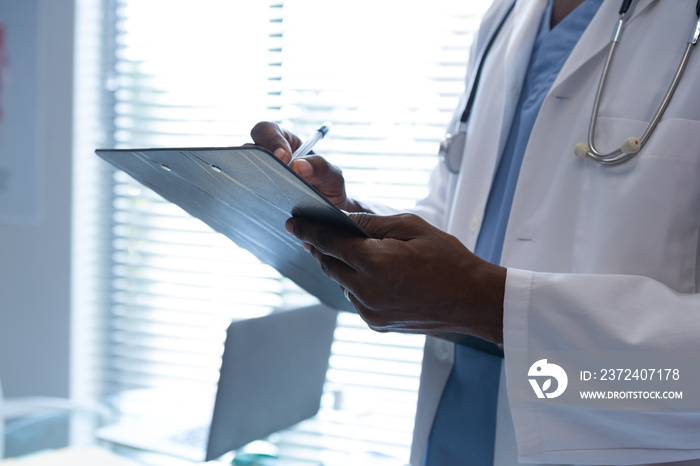 Male doctor writing on a clipboard in the hospital